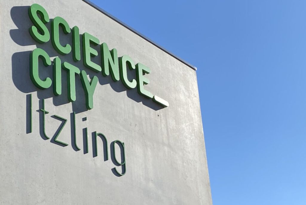 Grüner Schriftzug Science City Itzling- erhabene Buchstaben auf Betonpylon